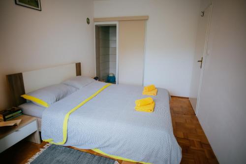 a bedroom with a large bed with yellow pillows at Petros apartmani in Vukovar