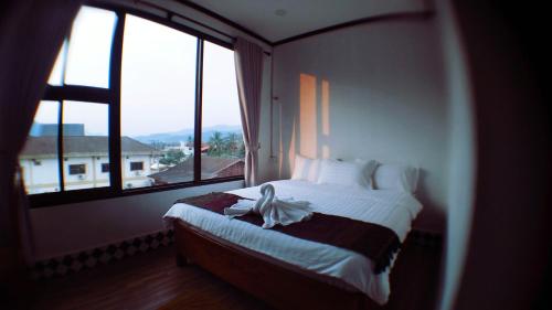 1 dormitorio con 1 cama y ventana grande en SD View Hotel, en Vang Vieng