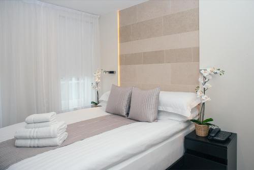 a bed with white sheets and pillows on it at NOX Golders Green in London