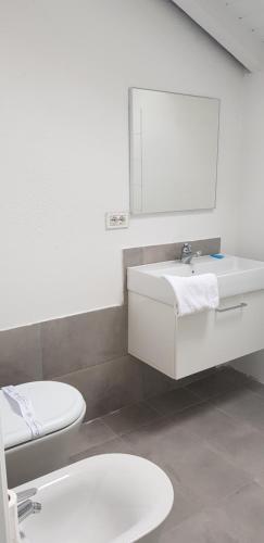 a bathroom with a white sink and a toilet at boat house facing the lake in Orta San Giulio