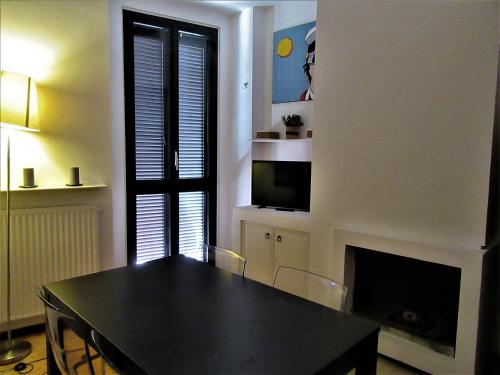 a dining room with a black table and a fireplace at Palazzo Velli Suites in Rome