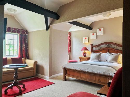 um quarto com uma cama, uma cadeira e uma janela em Mallyan Spout Hotel em Goathland