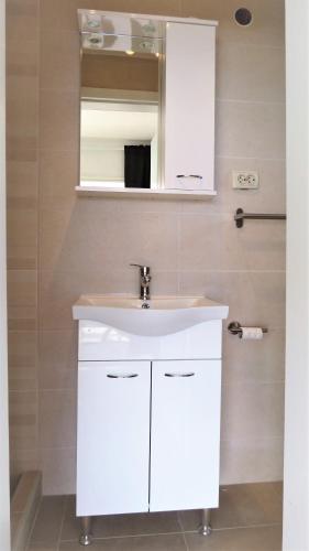 a bathroom with a white sink and a mirror at Villa Kornati in Tkon
