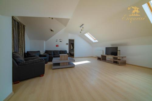 a living room with a couch and a tv at Villa Etiquette in Deva