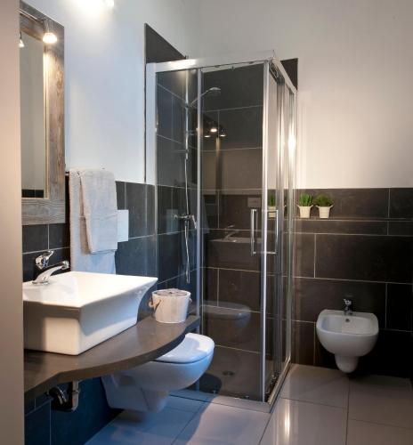 a bathroom with a sink and a shower and a toilet at Le Suites - di fronte Ospedale Sacro Cuore in Negrar