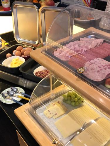 a buffet with meats and eggs and other food at Hotel Peterchens Mondfahrt in Fulda