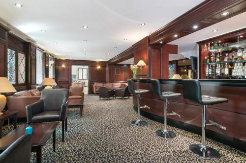 a bar in a hotel with chairs and a bar counter at Hôtel de l'Europe by HappyCulture in Strasbourg