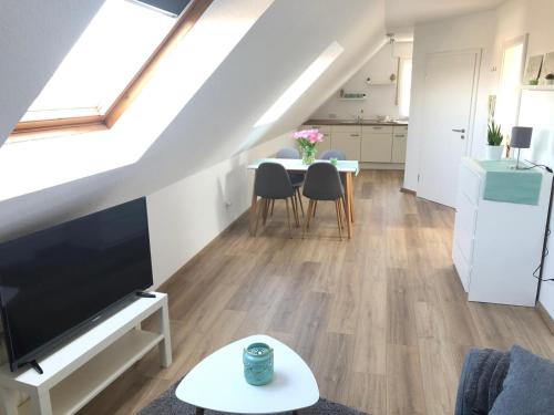 a living room with a television and a table with chairs at Ferienwohnung Xanten in Xanten