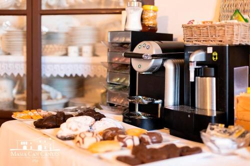 Masia Can Canyes & Spa في San Lorenzo de Hortóns: كونتر مع آلة صنع القهوة والكثير من الكعك