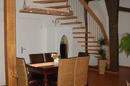 a dining room with a table and a staircase at Ferienwohnung Wildrose in Badbergen