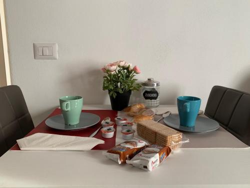 een tafel met twee borden eten en bloemen erop bij H & B Corte Ponti in Vermezzo