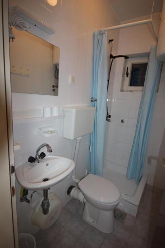 a bathroom with a sink and a toilet and a shower at Apartmani Pavičić-Ivelja in Stari Grad