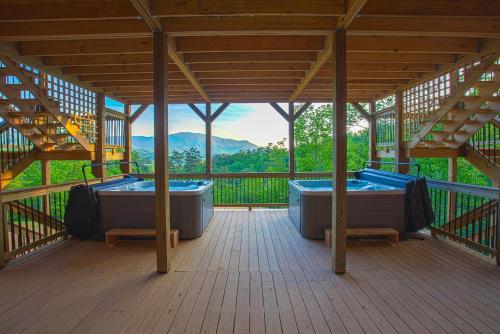 a wooden deck with two hot tubs in a building at Gatlinburg Mansion Cabin in Pittman Center