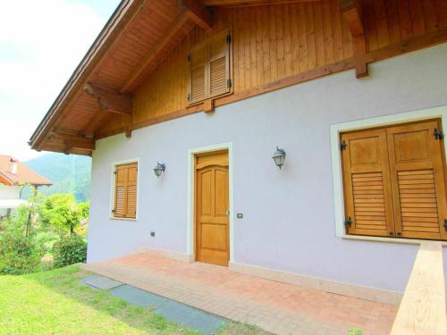 a house with wooden doors on the side of it at Belvilla by OYO Fior di melo in Caldes