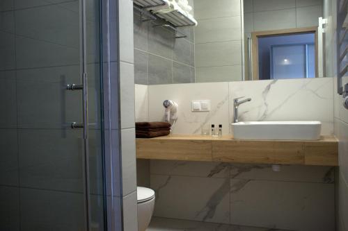 uma casa de banho com um lavatório, um WC e um espelho. em Family Resort Sarbinowo em Sarbinowo