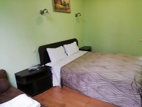 a bedroom with a bed and a nightstand with a bed sidx sidx at Guesthouse Aragats in Adler