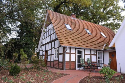 a white and black house with a table and chairs at Ferienwohnung Wildrose in Badbergen