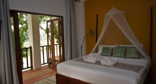 a bedroom with a bed with a canopy at Moonlight Champa Riverview in Luang Prabang