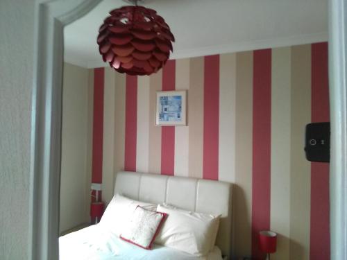 a bedroom with a bed with a red and white striped wall at The Iverna in Eastbourne