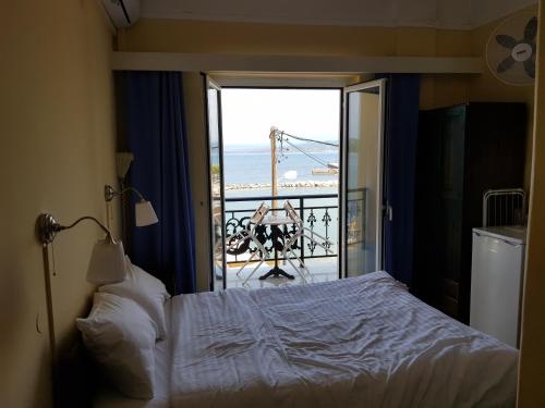 a bedroom with a bed and a view of the ocean at Hotel Miramare in Pylos