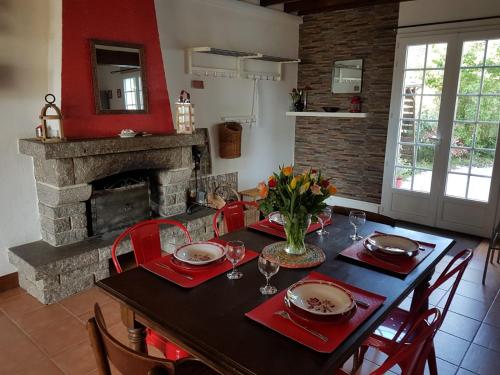 une salle à manger avec une table et une cheminée dans l'établissement La Casa Céline, à Surtainville