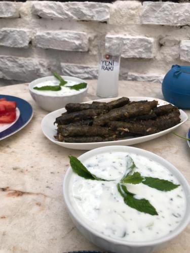 a table topped with plates of food and dip at Halikarnas Pansiyon in Bodrum City
