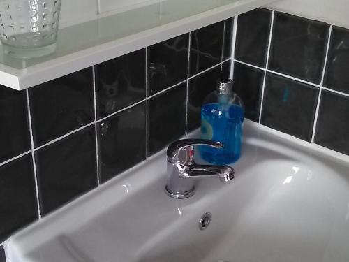 a bathroom sink with a blue soap bottle on it at The Iverna in Eastbourne