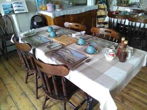 a dining room table with a white table cloth and chairs at The Iverna in Eastbourne