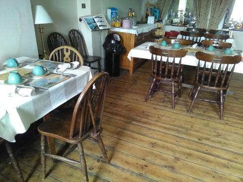 a dining room with a table and wooden chairs at The Iverna in Eastbourne