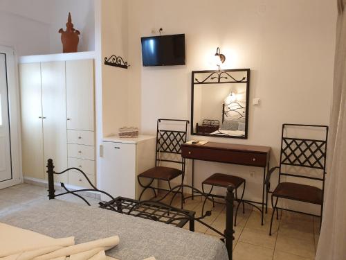 Sifnos Hotel Benaki في بلاتيس ييالوس سيفنوس: غرفة نوم مع طاولة تزيين ومرآة
