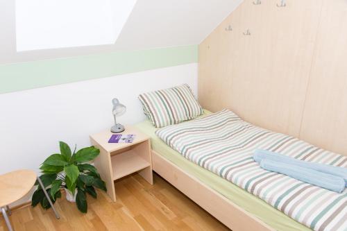 a small room with a bed and a night stand at Apartma Murania in Lendava