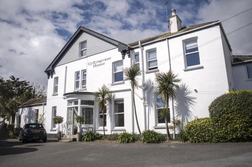 a white house with palm trees in front of it at Gyllyngvase House in Falmouth