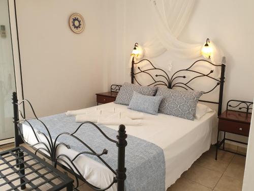 a bedroom with a black and white bed with pillows at Sifnos Hotel Benaki in Platis Yialos Sifnos