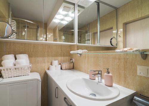 a bathroom with a sink and a mirror at Royal Garden Apartment in Warsaw