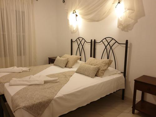 a bedroom with two beds with white sheets and pillows at Sifnos Hotel Benaki in Platis Yialos Sifnos