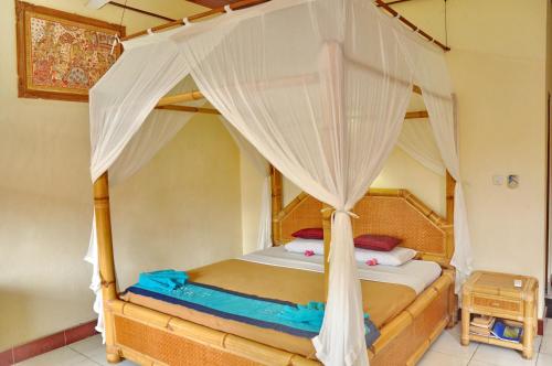 una camera con letto a baldacchino di Nick's Homestay ad Ubud