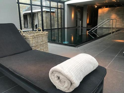 a white towel is sitting on a black couch at Manoir de Lébioles in Spa