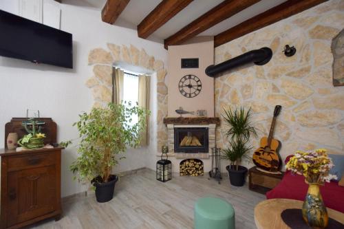 a living room with a stone wall with a fireplace at Apartments Neven in Čižići