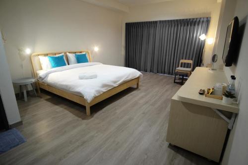 a hotel room with a large bed with blue pillows at Siam Mansion - SHA in Hat Yai
