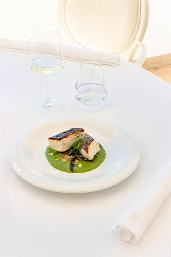 a plate of food on a table with wine glasses at Hotel Miramare & Spa in Sestri Levante