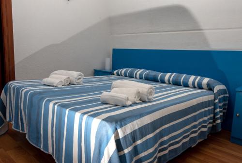 a blue and white bed with towels on it at Hotel & Spa Relais Freedom Club in Massa Lubrense