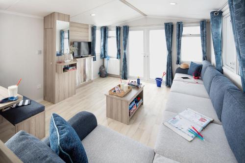 sala de estar con sofá azul y TV en Camping 't Veerse Meer, en Wolphaartsdijk