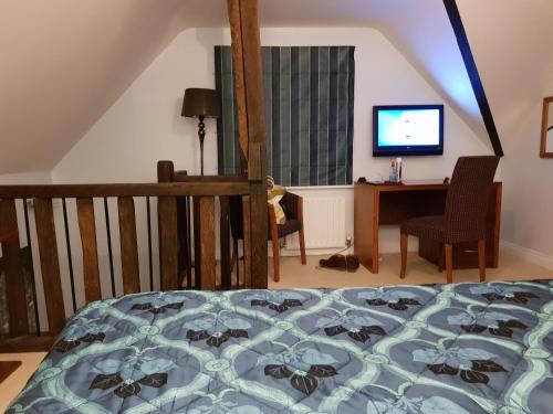 Schlafzimmer mit einem Bett, einem Schreibtisch und einem TV in der Unterkunft Ye Olde Red Lion in Newbury