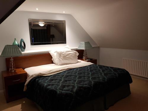 um quarto com uma cama com um espelho e 2 candeeiros em Ye Olde Red Lion em Newbury