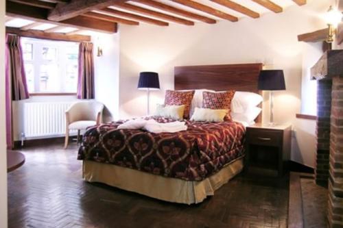 ein Schlafzimmer mit einem Bett, einem Stuhl und einem Fenster in der Unterkunft Ye Olde Red Lion in Newbury