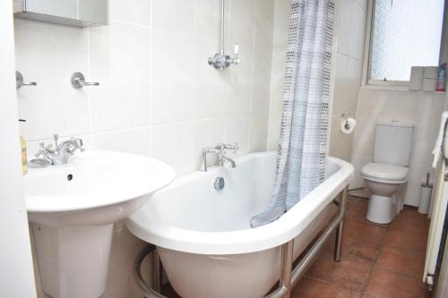 La salle de bains est pourvue d'une baignoire, d'un lavabo et de toilettes. dans l'établissement East Claremont - beautiful 2BR apartment in Central Edinburgh, à Édimbourg