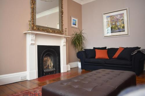 - un salon avec un canapé noir et une cheminée dans l'établissement East Claremont - beautiful 2BR apartment in Central Edinburgh, à Édimbourg