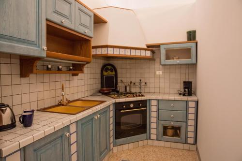 a kitchen with blue cabinets and a stove top oven at Chiama Ride the Beauty Assisi in Assisi