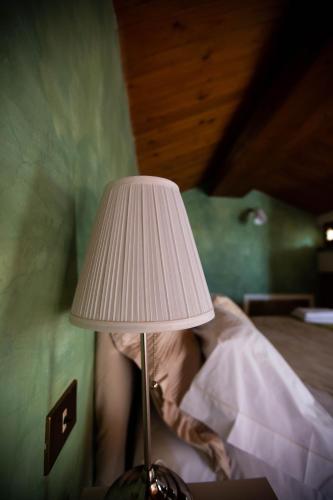 a lamp sitting on a table next to a bed at Chiama Ride the Beauty Assisi in Assisi