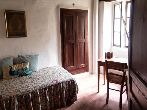- une chambre avec un lit, un bureau et une fenêtre dans l'établissement Le Pontin, à Mane
